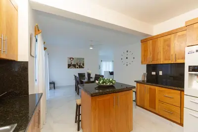 a kitchen with wooden cabinets and a black counter top at Crown ll-3 Bedrooms-Pool-Close to everything! in San Felipe de Puerto Plata