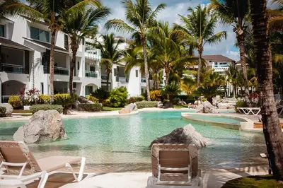 a resort swimming pool with chairs and palm trees at 104 PL - Elegante y moderno, posición perfecta in La Laguna
