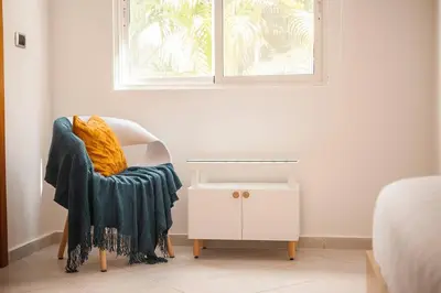 a chair with a blanket sitting under a window at 104 PL - Elegante y moderno, posición perfecta in La Laguna