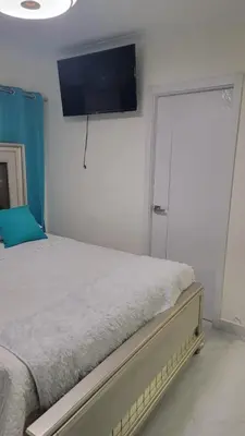 a bedroom with a bed with a flat screen tv on the wall at Klinda Luxury Home Apartament Mi Casa es tu Casa in Mendoza