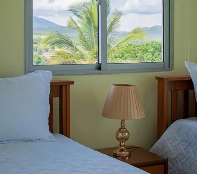 a bedroom with a bed and a window with a palm tree at Villas Vallejuelo in Vallejuelo