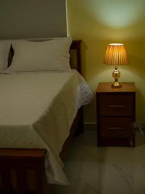 a bedroom with a bed with a lamp on a night stand at Villas Vallejuelo in Vallejuelo