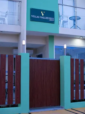 a fence in front of a building with a sign at Villas Vallejuelo in Vallejuelo