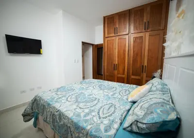 a bedroom with a bed and a wooden cabinet at Divine Stay 3 Bedroom One minute from the beach on the malecon in San Felipe de Puerto Plata