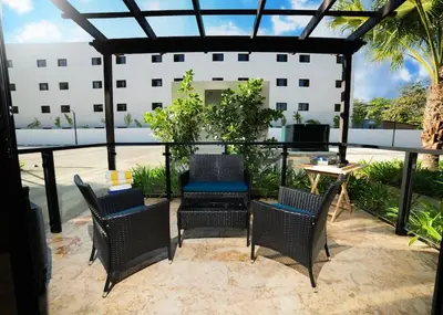 a patio with chairs and a table and a building at Divine Stay 3 Bedroom One minute from the beach on the malecon in San Felipe de Puerto Plata