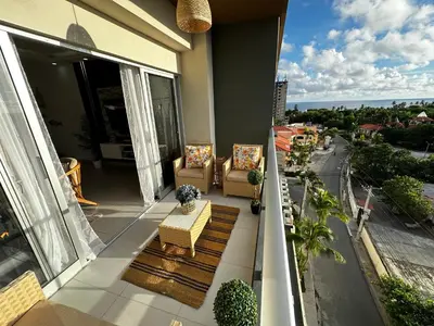 a balcony with two chairs and a view of a street at Acogedor Apartamento en JUAN DOLIO in Los Corrales