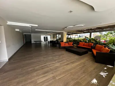an empty room with couches and chairs in a building at Acogedor Apartamento en JUAN DOLIO in Los Corrales