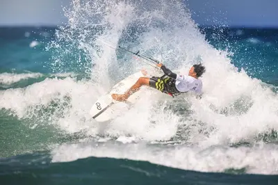 a man riding a wave on a surfboard in the ocean at KITE BEACH HOTEL Oceanfront Apartments in Cabarete