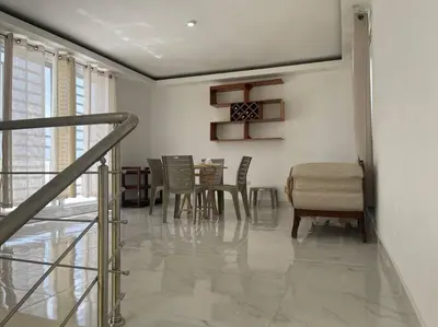 a living room with a table and chairs and a staircase at Modern House in Santo Domingo Este in Juan López