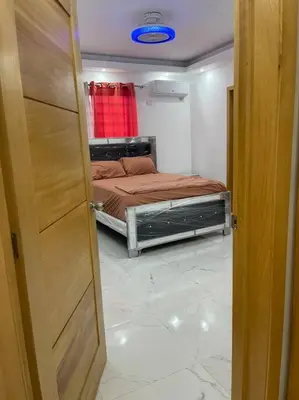 a door to a bedroom with a bed in a room at Modern House in Santo Domingo Este in Juan López