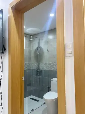 a bathroom with a toilet and a glass shower at Modern House in Santo Domingo Este in Juan López