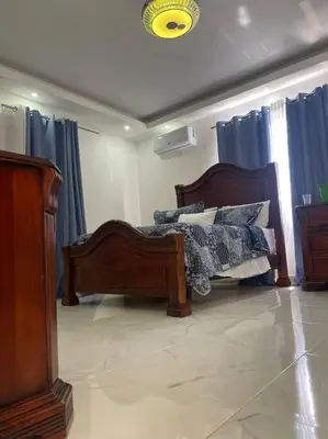 a bedroom with a bed and blue curtains at Modern House in Santo Domingo Este in Juan López