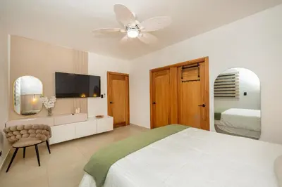 a white bedroom with a bed and a ceiling fan at Pool & Gym - 10min Aeropuerto y HOMS - Dream Stay in Santiago de los Caballeros