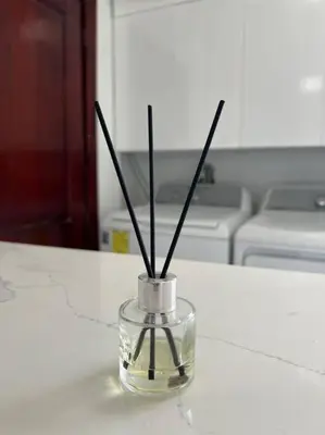 a glass vase with sticks in it on a counter at Encantador y lujoso apartamento in San Pedro de Macorís