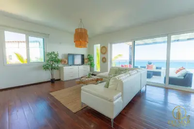 a living room with a white couch and a television at Brisas del norte in Sosúa