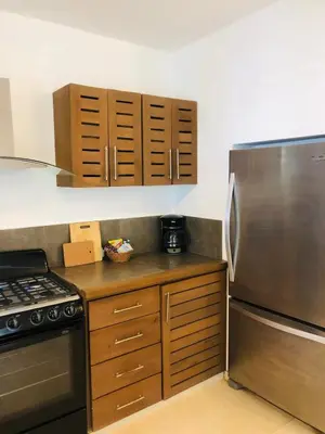a kitchen with a stainless steel refrigerator and wooden cabinets at Tropical Villa 4Bedroom 3Baths and Pool Near Beach in Las Terrenas