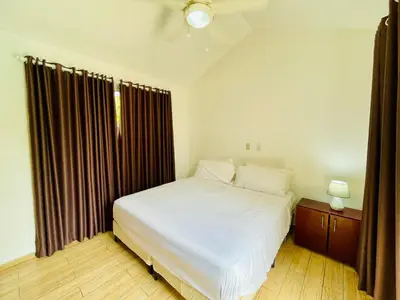 a bedroom with a large white bed and a window at Casa feliz in Sosúa