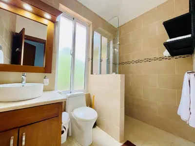 a bathroom with a sink and a toilet and a mirror at Casa feliz in Sosúa