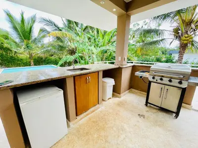 a kitchen with a counter with a stove and a window at Casa feliz in Sosúa