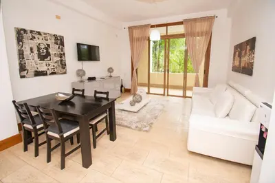 a living room with a table and a white couch at Apto en Casa de Campo en Los Altos 2 in La Romana