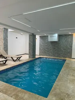 a large swimming pool in a building with blue water at Apartment in Santo Domingo este in Juan López