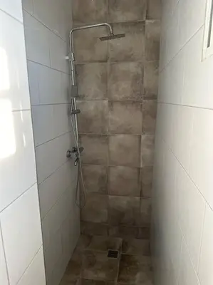 a bathroom with a shower with a tiled floor and a shower at Apartment in Santo Domingo este in Juan López