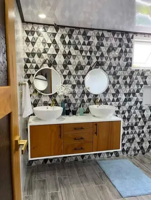 a bathroom with two sinks and two mirrors at Villa Naturaleza y confort in Santiago de los Caballeros