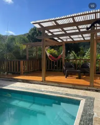 a hammock under a pergola next to a pool at Villa Naturaleza y confort in Santiago de los Caballeros