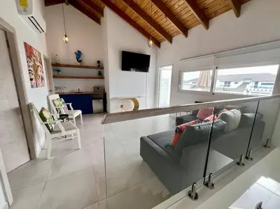 a person sitting on a couch in a living room at AD-301 Ático Duplex Estrella Dominicus in La Laguna