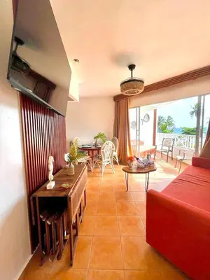 a living room with a red couch and a table at Estancia Nana apartamento vista al mar piscina WIFI cocina completa aire acondicionado Lavadora secadora in Juan Dolio