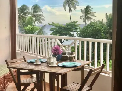 a table on a balcony with a view of the ocean at Estancia Nana apartamento vista al mar piscina WIFI cocina completa aire acondicionado Lavadora secadora in Juan Dolio