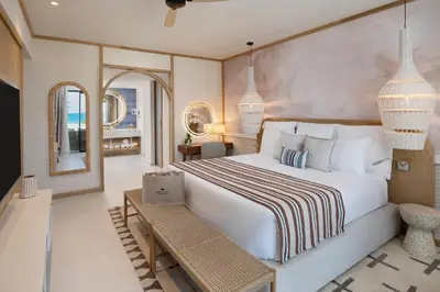 a bedroom with a large bed and a table at Dreams Playa Esmeralda Resort & Spa - All Inclusive in Miches
