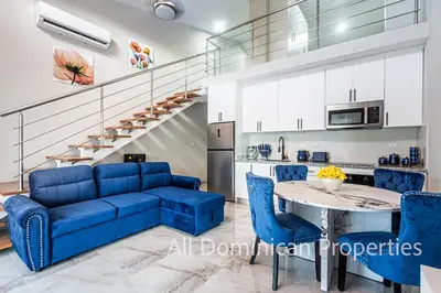 a living room with a blue couch and a table at Hill Side Condos - Hispaniola in Sosúa