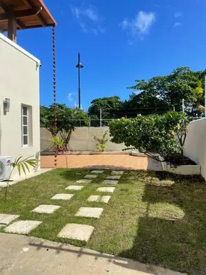 a yard with grass and stones in front of a building at Villa familiar con vista al océano in San Felipe de Puerto Plata