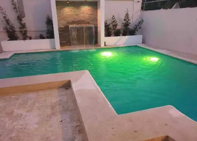 a swimming pool with green water in a building at Villa familiar con vista al océano in San Felipe de Puerto Plata