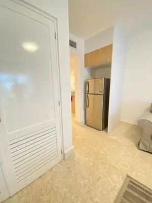 a kitchen with a refrigerator and a door to a room at Apartamento de playa in San Felipe de Puerto Plata