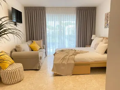 a bedroom with a bed and a couch and a window at Apartamento de playa in San Felipe de Puerto Plata