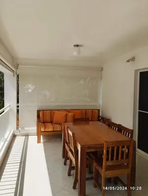 a dining room with a wooden table and a couch at Residencial caoba in Las Terrenas
