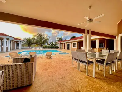 a patio with a table and chairs next to a pool at Casa Linda Club in Sosúa