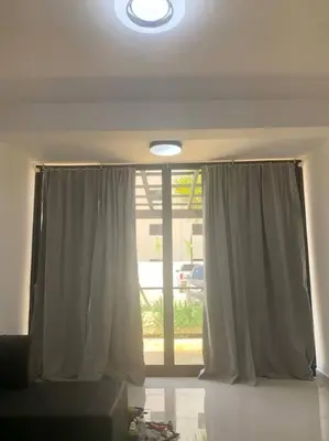 a living room with a window with a curtain at New Beachfront at Sunset Apartments 3 Bedroom 2 Bath Gym Pool PS5 in San Felipe de Puerto Plata