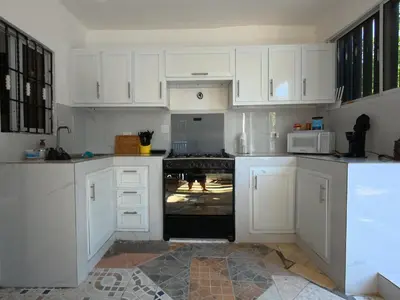 a kitchen with white cabinets and an oven at Villa Cordero - Las Calderas Bani in Baní