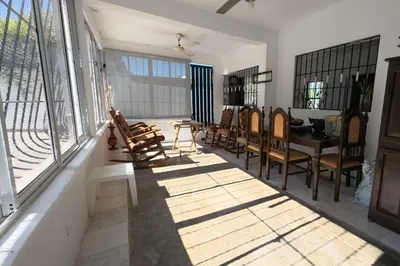 a room with chairs and a table and windows at Villa Cordero - Las Calderas Bani in Baní