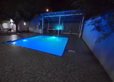 a swimming pool with blue lighting at night at Villa Cordero - Las Calderas Bani in Baní