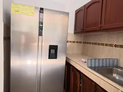 a stainless steel refrigerator in a kitchen next to a sink at Villa Cordero - Las Calderas Bani in Baní