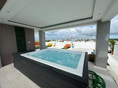 a hot tub on a patio with a view of the beach at Apartamento santo domingo este in Juan López
