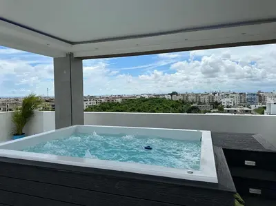 a hot tub on a balcony with a view of a city at Apartamento santo domingo este in Juan López