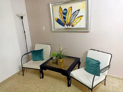 a living room with two chairs and a coffee table at Habitacion en el centro in La Julia