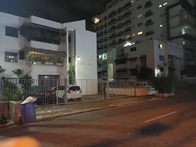a city street at night with a fence and buildings at Habitacion en el centro in La Julia
