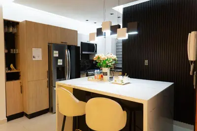 a kitchen with a island with two chairs and a counter at Apartamento en el gran santo Domingo in Santo Domingo
