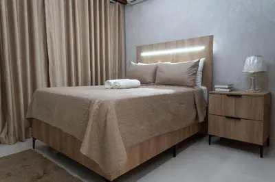 a bedroom with a bed and a night stand with a lamp at Apartamento en el gran santo Domingo in Santo Domingo